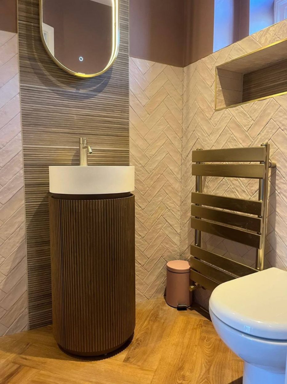Cloakroom with fluted pedestal basin and herringbone tiles