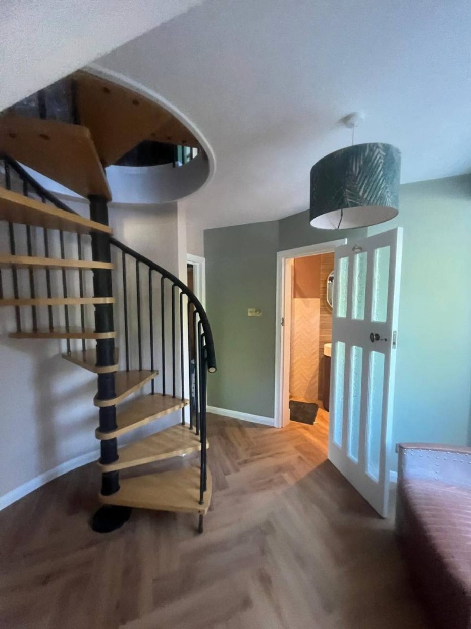 Hallway with spiral staircase and herringbone floor